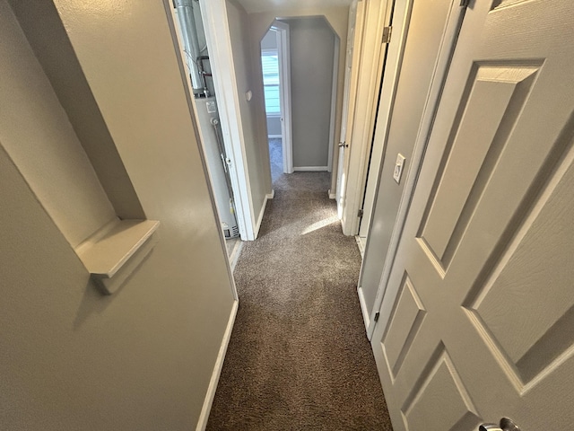 corridor featuring dark colored carpet