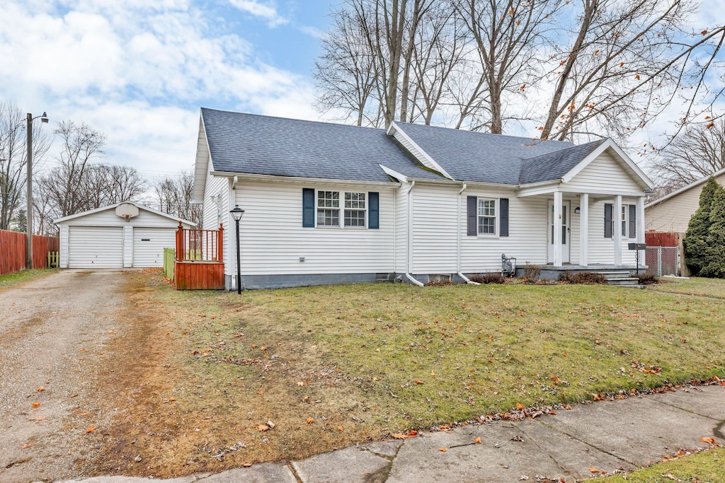 view of front of property with a garage, an outbuilding, and a front yard