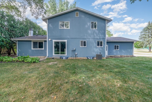 rear view of house with a lawn and central AC unit