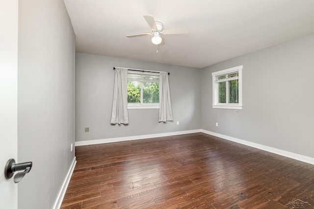 empty room with dark hardwood / wood-style floors and ceiling fan