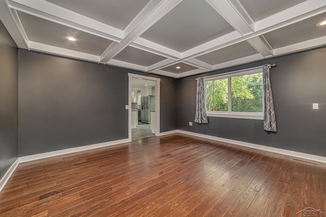 empty room featuring wood-type flooring, coffered ceiling, and beam ceiling