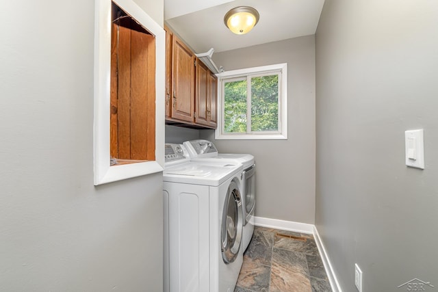 clothes washing area featuring cabinets and independent washer and dryer