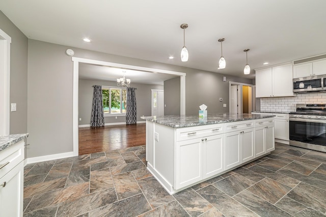 kitchen featuring white cabinets, pendant lighting, stainless steel appliances, and light stone counters