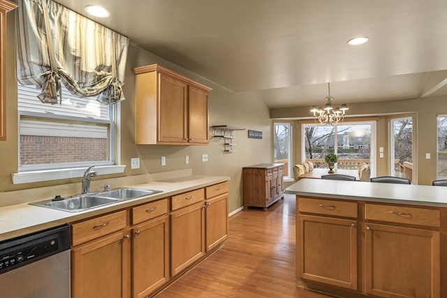 kitchen with sink, dishwasher, a notable chandelier, light hardwood / wood-style floors, and vaulted ceiling