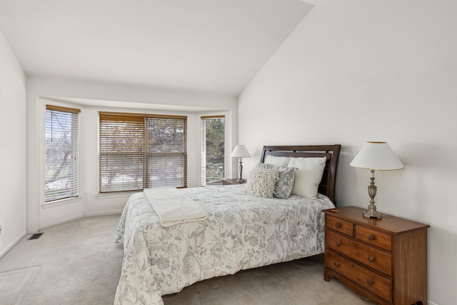 bedroom with light colored carpet and vaulted ceiling