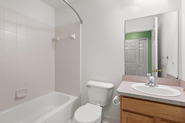 full bathroom featuring vanity, tiled shower / bath combo, and toilet