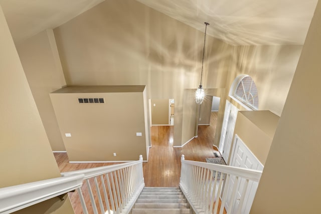 hallway featuring hardwood / wood-style floors and high vaulted ceiling