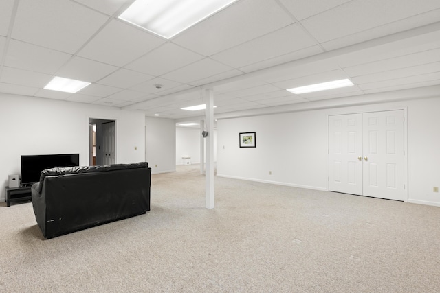 carpeted living room with a drop ceiling