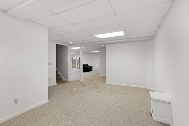 basement with a paneled ceiling and carpet floors