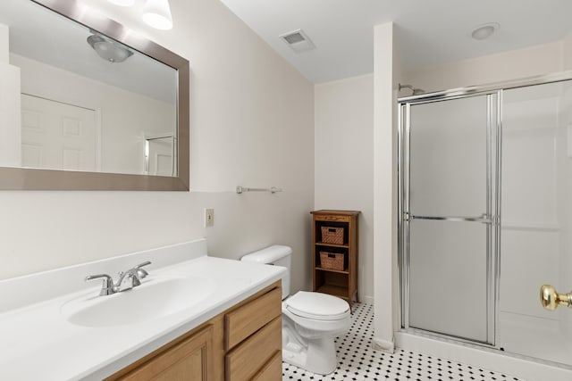 bathroom featuring tile patterned floors, toilet, an enclosed shower, and vanity