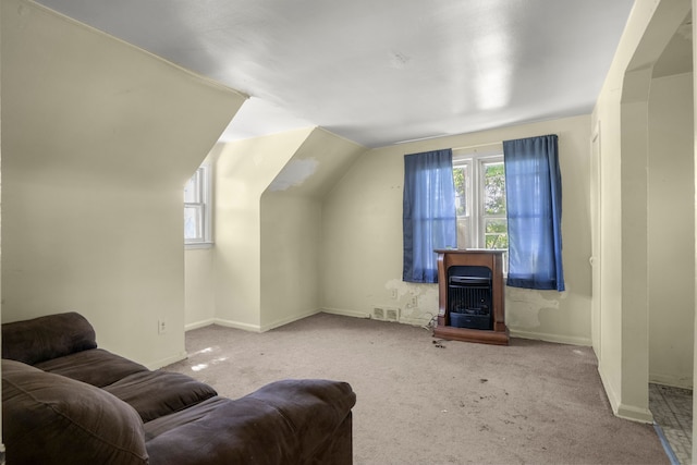 carpeted living room with a healthy amount of sunlight and vaulted ceiling