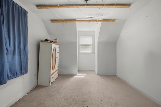 additional living space featuring light carpet and vaulted ceiling with beams