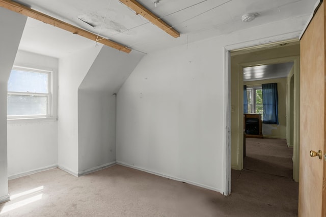 additional living space with light carpet and vaulted ceiling with beams