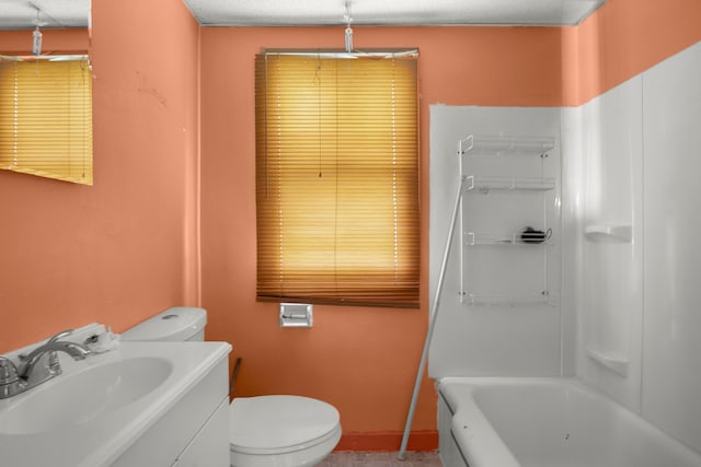 bathroom with a textured ceiling, vanity, a tub to relax in, and toilet