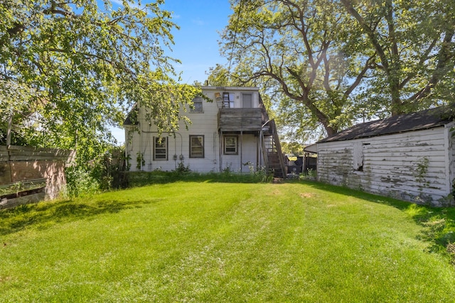 rear view of property with a lawn and a storage shed