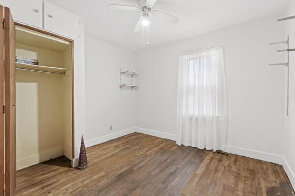 unfurnished bedroom featuring ceiling fan, a closet, and wood-type flooring