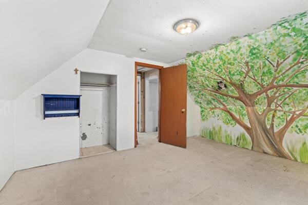 additional living space featuring light colored carpet and lofted ceiling