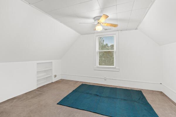 additional living space featuring carpet flooring, ceiling fan, and vaulted ceiling