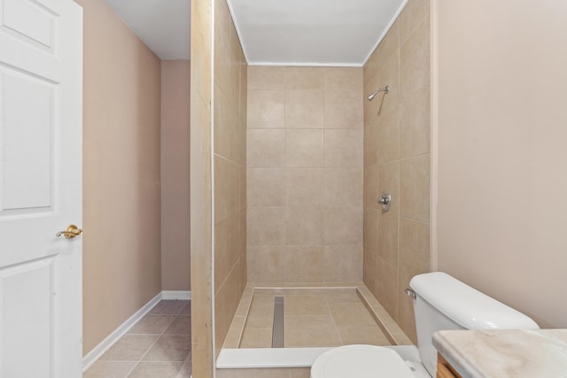 bathroom with tile patterned floors, toilet, and tiled shower