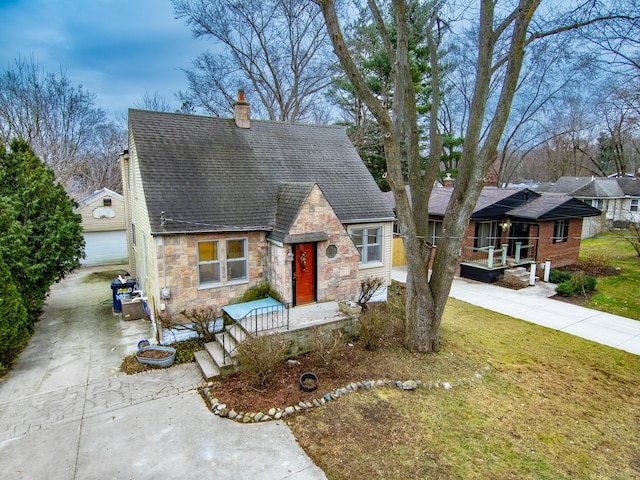 view of front of house with a garage, an outdoor structure, and a front lawn