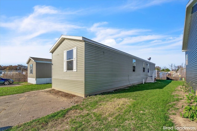 view of side of home with a yard