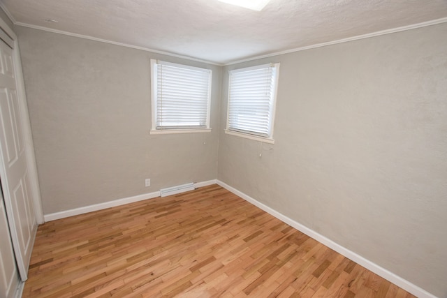 spare room featuring light hardwood / wood-style floors and ornamental molding