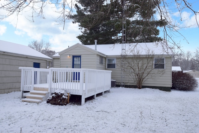 snow covered house featuring central AC and a wooden deck