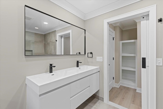 bathroom with wood-type flooring, vanity, and crown molding