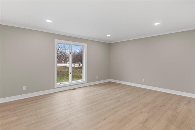 spare room featuring crown molding and light wood-type flooring