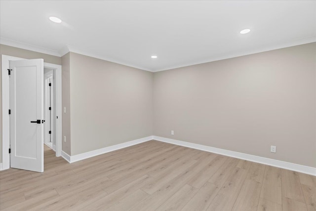 spare room featuring light wood-type flooring and ornamental molding