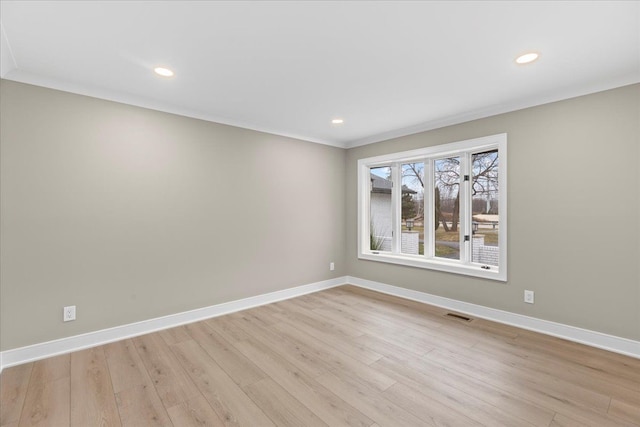 empty room with light hardwood / wood-style flooring and ornamental molding