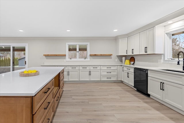 kitchen featuring black dishwasher, white cabinetry, and sink