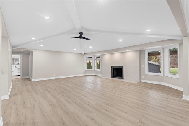 unfurnished living room with vaulted ceiling with beams, light hardwood / wood-style floors, a fireplace, and ceiling fan