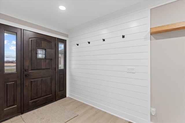 foyer with wood walls and light hardwood / wood-style flooring