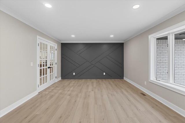 empty room featuring light wood-type flooring, crown molding, and french doors