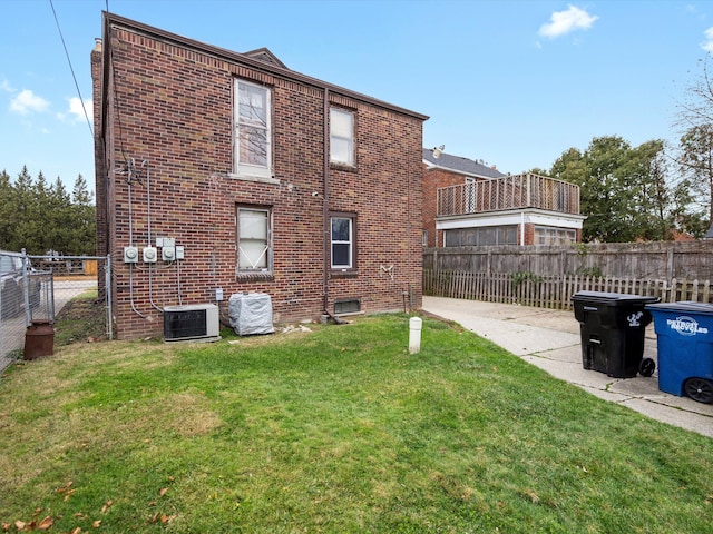 rear view of property with a lawn and central AC unit