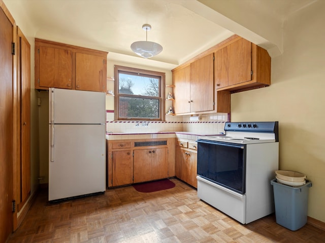 kitchen featuring decorative backsplash, white refrigerator, light parquet floors, and range with electric cooktop