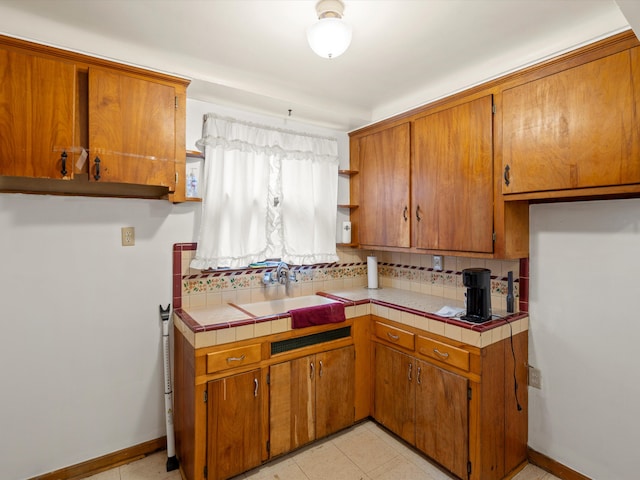 kitchen with tile countertops, sink, and light tile patterned floors