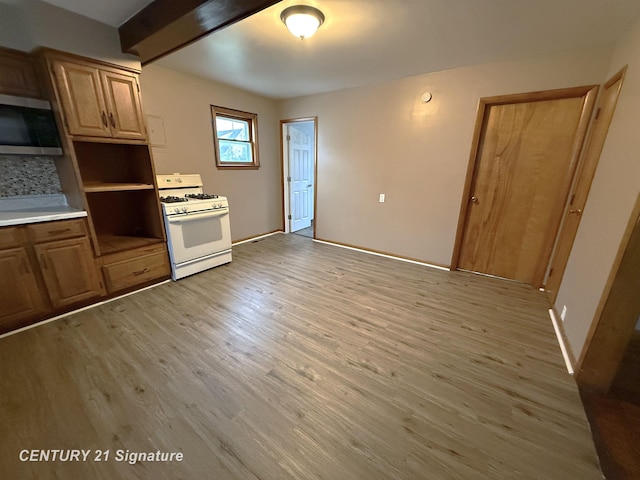 kitchen with decorative backsplash, beam ceiling, light hardwood / wood-style flooring, and gas range gas stove