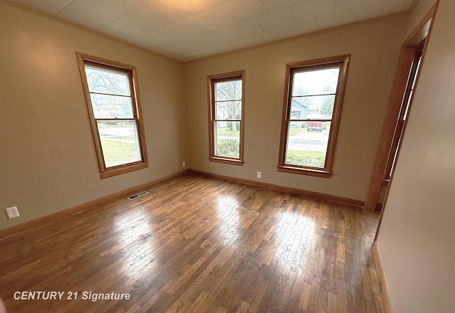 spare room with crown molding and dark wood-type flooring