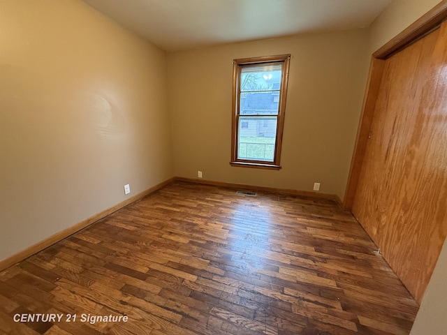 empty room with dark hardwood / wood-style floors