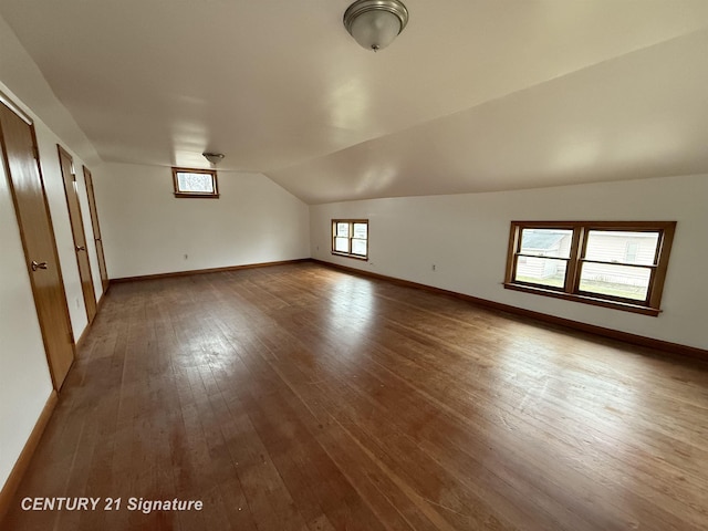 additional living space featuring lofted ceiling and hardwood / wood-style flooring