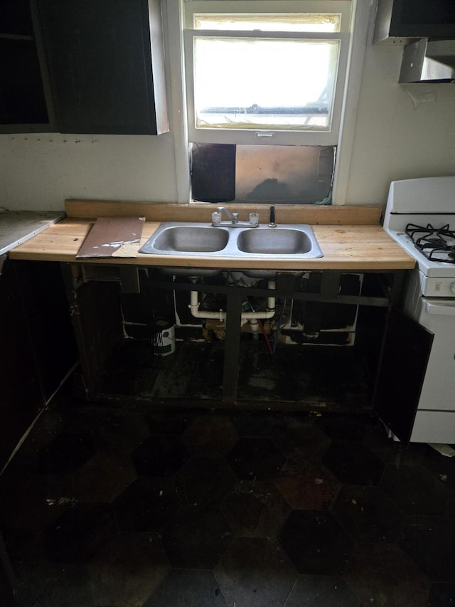 kitchen featuring wooden counters, white gas range oven, and sink