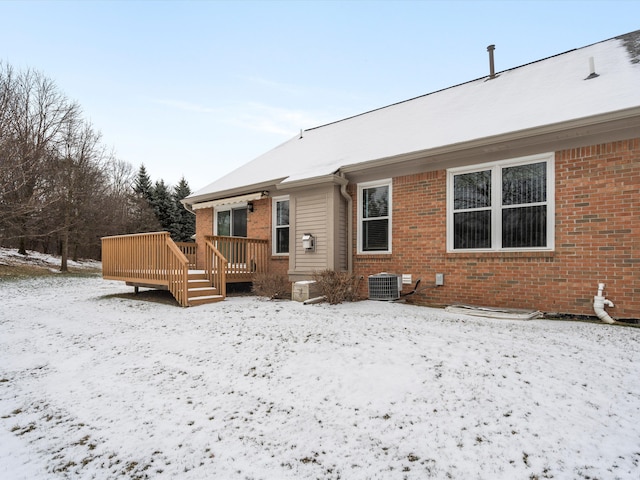 snow covered property featuring a deck and cooling unit