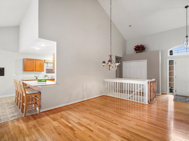 entryway featuring plenty of natural light, high vaulted ceiling, and a notable chandelier