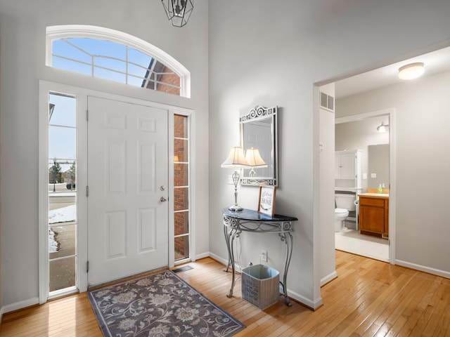 entrance foyer with light hardwood / wood-style floors and a high ceiling