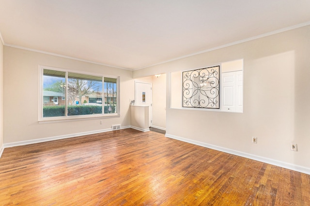 spare room featuring wood-type flooring and ornamental molding