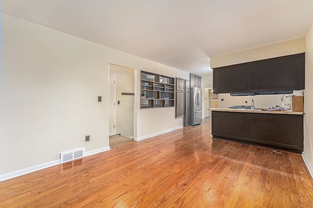 kitchen featuring light hardwood / wood-style floors, stainless steel fridge with ice dispenser, and kitchen peninsula