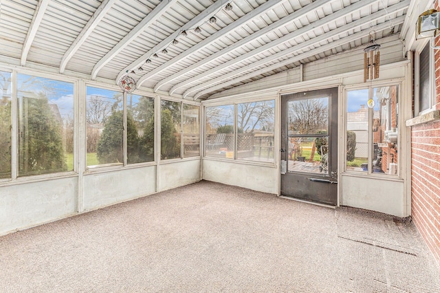 unfurnished sunroom featuring vaulted ceiling with beams