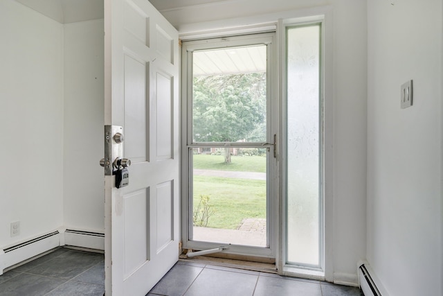 entryway with a wealth of natural light, light tile patterned flooring, and a baseboard heating unit